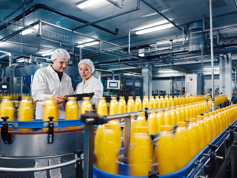 Påfyllning av apelsinjuice i en anläggning för dryckestillverkning