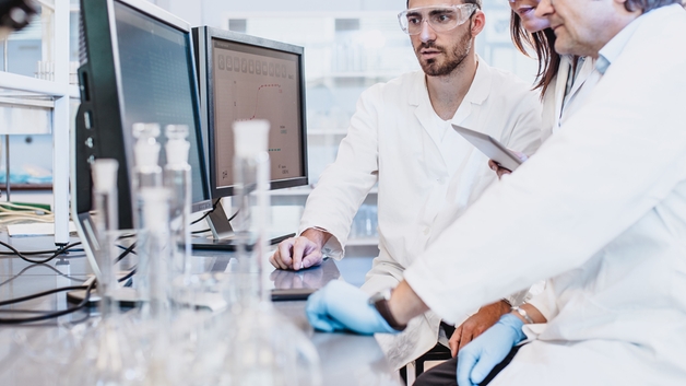 Forskare som arbetar i ett laboratorium och tittar på en dataskärm