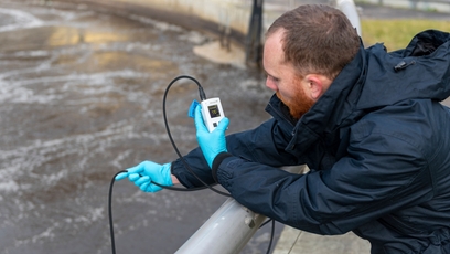 En man verifierar en mätpunkt för löst syre med en portabel syremätare