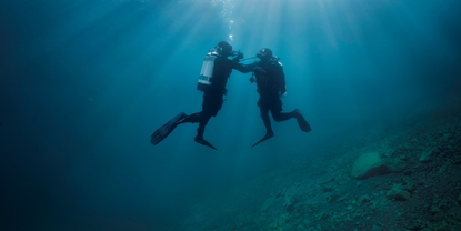 Under vatten: en dykare hjälper en annan dykare som har problem med lufttillförseln.