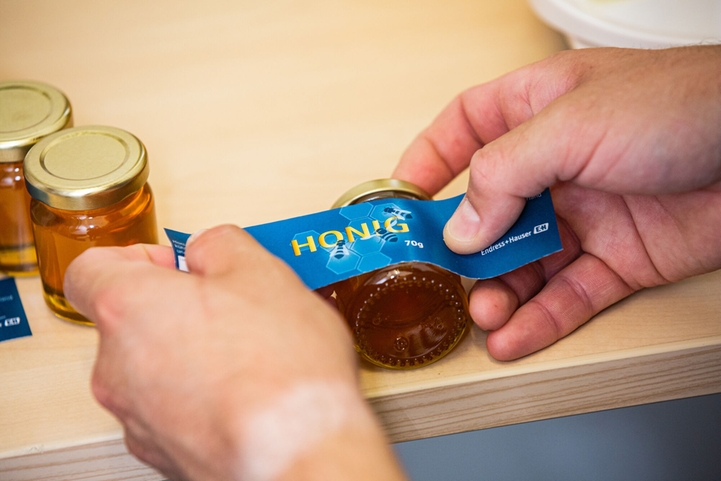 En anställd som utbildats till biodlare och som också sköter skörden och tappningen av honungen
